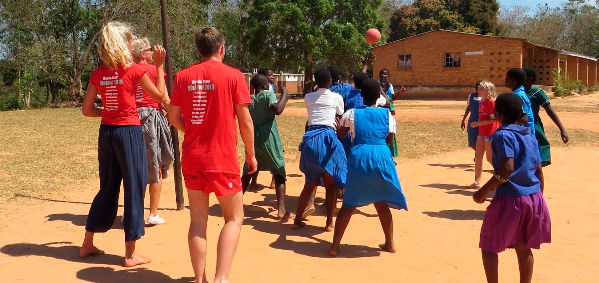 Volunteers playing netball with school children